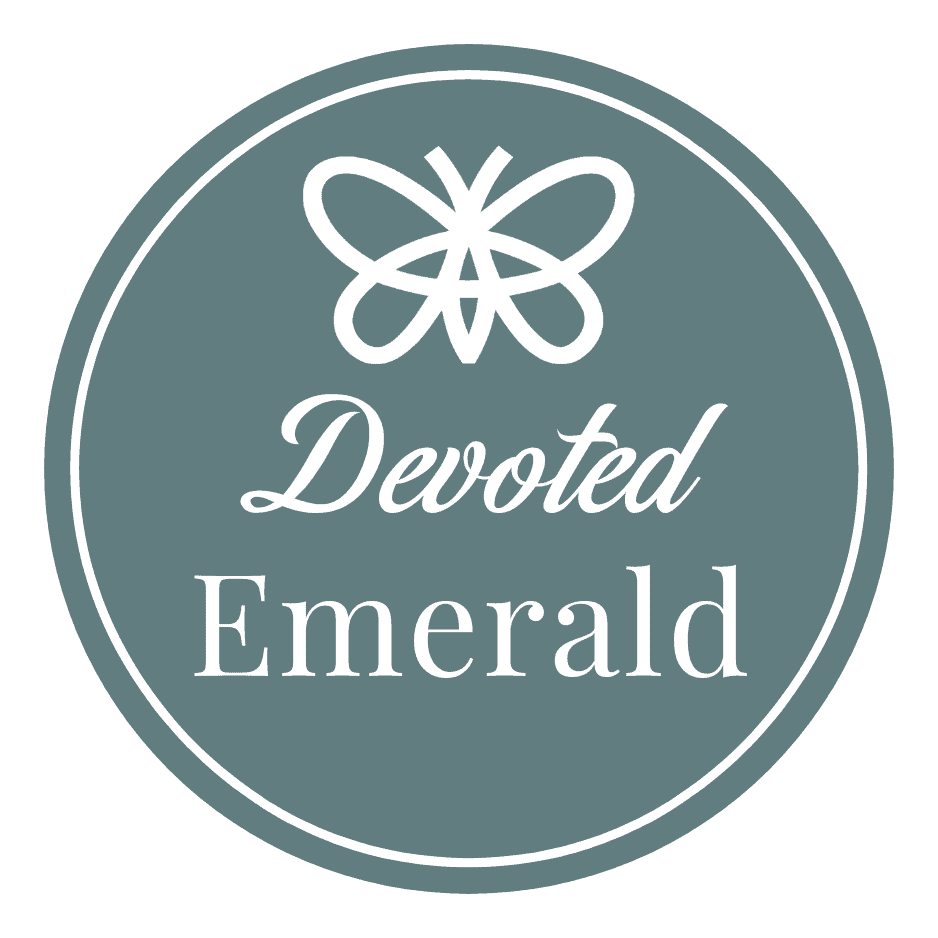 A circular taupe logo features a white butterfly icon above the words "Devoted Emerald" in script and serif fonts.