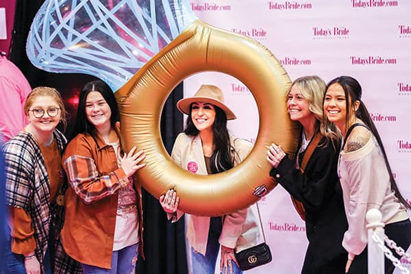 A group of women pose for a photo with a giant ring
