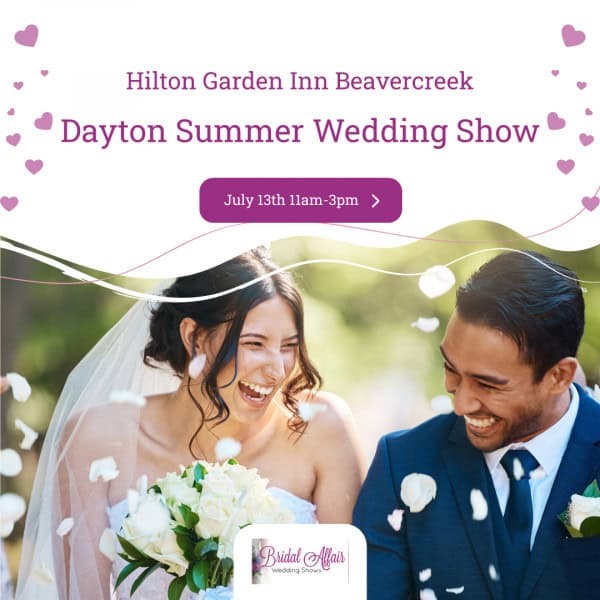 Bride and groom smiling as flower petals fall, promoting the Dayton Summer Wedding Show at Hilton Garden Inn Beavercreek on July 13th from 11am to 3pm.